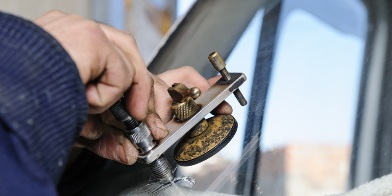 Repair cracked windshield. Fitter is using Windshield Repair Crack Bridge.