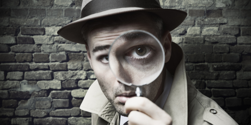 Funny vintage detective looking through a magnifier